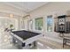 Elegant game room features tile floors, coffered ceiling, and ample natural light at 13661 Granger Ave, Orlando, FL 32827