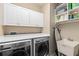 Functional laundry room with white cabinets, ample counter space, washer, dryer and utility sink at 13661 Granger Ave, Orlando, FL 32827