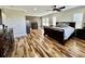 Spacious main bedroom with a decorative wall, hardwood floors, a ceiling fan, and a large bed with comfortable pillows at 13661 Granger Ave, Orlando, FL 32827