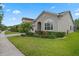 Street view of a well-maintained home with a lush green lawn, complemented by a paved driveway and thoughtful landscaping at 14072 Alafaya Oak Bnd, Orlando, FL 32828