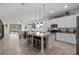 Modern kitchen featuring an island with seating, stainless steel appliances, and open view to dining and living areas at 14072 Alafaya Oak Bnd, Orlando, FL 32828