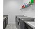 Efficient laundry room with granite countertop, sink, modern washer and dryer, and functional overhead storage at 14072 Alafaya Oak Bnd, Orlando, FL 32828