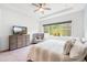 Bright main bedroom featuring neutral tones, tray ceilings, carpeting, and ample natural light at 14072 Alafaya Oak Bnd, Orlando, FL 32828