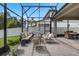 Spacious screened patio with comfortable seating area and a dining area, perfect for outdoor entertaining and relaxation at 14072 Alafaya Oak Bnd, Orlando, FL 32828