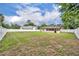 Large grassy backyard showcasing the home's fence line, exterior, and screened in patio space at 150 Tarpon Cir, Winter Springs, FL 32708