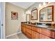 Bathroom with a double sink vanity, granite countertop, and decorative mirrors at 150 Tarpon Cir, Winter Springs, FL 32708