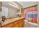 A bathroom featuring a granite countertop, a sink with decoratives, and a shower/tub with colorful curtains at 150 Tarpon Cir, Winter Springs, FL 32708