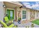 Inviting porch with green door, stone accents, seating, and decorative plants at 150 Tarpon Cir, Winter Springs, FL 32708
