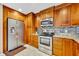 Stainless steel appliances and wood cabinets in this remodeled, tiled kitchen at 150 Tarpon Cir, Winter Springs, FL 32708