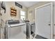 This is a laundry room including a washer, dryer, window, shelving, laundry detergent, and access to the backyard at 150 Tarpon Cir, Winter Springs, FL 32708