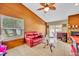 Cozy living room features wood-paneled walls, a red leather sofa, and a stone fireplace, creating a warm and inviting space at 150 Tarpon Cir, Winter Springs, FL 32708