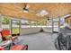 This is a furnished and screened porch with a ceiling fan, skylight, and a partial view of the yard at 150 Tarpon Cir, Winter Springs, FL 32708