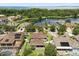 Aerial view showcasing the neighborhood, lake, mature trees, and manicured lawns at 1501 Prairie Oaks Dr, St Cloud, FL 34771