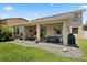 Covered back patio features a hot tub, fan, and outdoor seating area with lush green grass at 1501 Prairie Oaks Dr, St Cloud, FL 34771