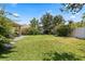 Spacious backyard features lush green grass, landscaping, and a charming windmill at 1501 Prairie Oaks Dr, St Cloud, FL 34771