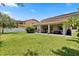 Expansive backyard featuring lush green grass, covered patio, and ample space for outdoor activities at 1501 Prairie Oaks Dr, St Cloud, FL 34771