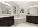 Elegant bathroom featuring dual vanities, a soaking tub, and modern fixtures at 1501 Prairie Oaks Dr, St Cloud, FL 34771