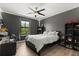 Cozy bedroom with modern ceiling fan, gray walls, wood floor, and natural light from window at 1501 Prairie Oaks Dr, St Cloud, FL 34771
