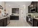Well-equipped kitchen with dark cabinetry, tile backsplash, and modern appliances at 1501 Prairie Oaks Dr, St Cloud, FL 34771