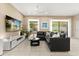 Comfortable living room featuring a large sectional sofa, flat-screen TV, and natural light at 1501 Prairie Oaks Dr, St Cloud, FL 34771