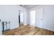 Living room with wood-look flooring, white walls, and an open doorway to another room at 1507 Sw 4Th St, Ocala, FL 34471