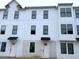 Modern townhouse featuring white siding, black trim windows, and brick accents at the entryways at 15083 Grove Lake Dr, Winter Garden, FL 34787