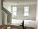 Bright living room area with staircase, two windows, and unfinished flooring at 15083 Grove Lake Dr, Winter Garden, FL 34787