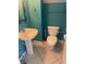 Turquoise bathroom featuring a pedestal sink and standard toilet with tiled flooring at 1921 Stone Abbey Blvd, Orlando, FL 32828