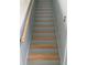 A gray staircase featuring light-colored wood steps and a wooden handrail at 1921 Stone Abbey Blvd, Orlando, FL 32828