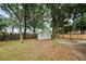View of backyard featuring a small shed and fire pit with mature trees at 1957 Deloy Dr, Daytona Beach, FL 32119