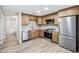 Updated kitchen featuring stainless steel appliances, wood cabinets, quartz counters, and modern flooring at 1957 Deloy Dr, Daytona Beach, FL 32119