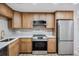 Updated kitchen featuring stainless steel appliances, wood cabinets, quartz counters, and modern flooring at 1957 Deloy Dr, Daytona Beach, FL 32119