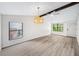 Bright living room showcasing light wood flooring, stylish light fixture, and large windows for natural light at 1957 Deloy Dr, Daytona Beach, FL 32119