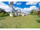 A charming single-story house with white exteriors surrounded by a well-maintained lawn and landscaping at 2498 Iris Rd, Deland, FL 32724