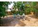 Leafy backyard with wooden fence, three chairs, and fire pit offers a peaceful outdoor space at 254 Oak Park Pl, Casselberry, FL 32707
