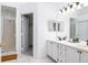 Bathroom featuring double sinks, framed mirrors, vanity lighting, and a glass-enclosed shower stall at 254 Oak Park Pl, Casselberry, FL 32707