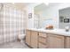 Bright bathroom with a double vanity, a large mirror, and a shower with a stylish patterned shower curtain at 254 Oak Park Pl, Casselberry, FL 32707
