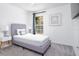 Minimalist bedroom with gray upholstered bed, soft carpet and a window offering natural light at 254 Oak Park Pl, Casselberry, FL 32707