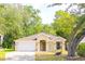 Charming single-story home with a well-maintained lawn and mature trees. Features a two-car garage and inviting front entrance at 254 Oak Park Pl, Casselberry, FL 32707