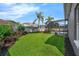 A fenced backyard featuring well-maintained grass and a screened-in pool area with an in-ground pool at 2643 University Acres Dr, Orlando, FL 32817