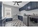 Well-equipped laundry room with stylish cabinetry, stainless steel appliances, and patterned tile flooring at 2643 University Acres Dr, Orlando, FL 32817