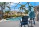 Backyard pool and patio with chairs and a privacy fence with tropical landscaping at 2643 University Acres Dr, Orlando, FL 32817