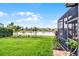 Expansive backyard with lush lawn, mature trees, and a screened lanai offering tranquil views of the waterfront at 2941 Marlberry Ln, Clermont, FL 34714