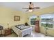 Bright bedroom with view of the water, ceiling fan and wood-look flooring at 2941 Marlberry Ln, Clermont, FL 34714