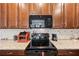 Close-up of kitchen with granite countertops, backsplash, stainless steel appliances, and dark wood cabinets at 2941 Marlberry Ln, Clermont, FL 34714