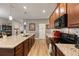 Open kitchen featuring granite countertops, stainless steel appliances, wood cabinets, and an island with sink and dishwasher at 2941 Marlberry Ln, Clermont, FL 34714