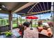 Relax on the screened lanai, featuring comfortable seating, outdoor cooking area, and serene pond views at 2941 Marlberry Ln, Clermont, FL 34714