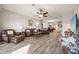 Expansive living room featuring wood-look tile floors, ample natural light, and comfortable seating at 2941 Marlberry Ln, Clermont, FL 34714