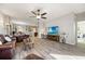 Open-concept living room with wood-look tile floors, comfortable seating, and a view into the adjacent dining and kitchen areas at 2941 Marlberry Ln, Clermont, FL 34714