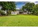 Expansive green backyard leading up to the home's back, featuring a cozy patio and lush landscaping at 3241 Downs Cove Rd, Windermere, FL 34786